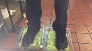 Burger King employee fired over this photo of his feet inshoes standing in 2 containers of shredded lettuce.