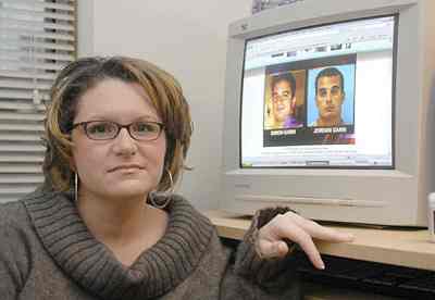 Meredith Gavin, a victim of Simon Gann and Jordan Gann poses with a photo of them on her computer