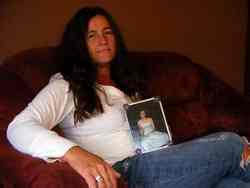 Cindy Young poses with a photo of her missing daughter, Christina Whittaker.