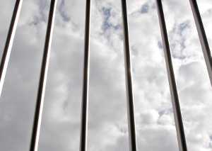 Photo of prison bars with clouds